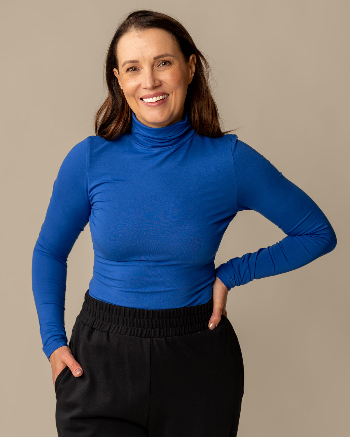 Woman wearing Poolo ultramariini turtleneck top made of LENZING™ ECOVERO™ viscose.