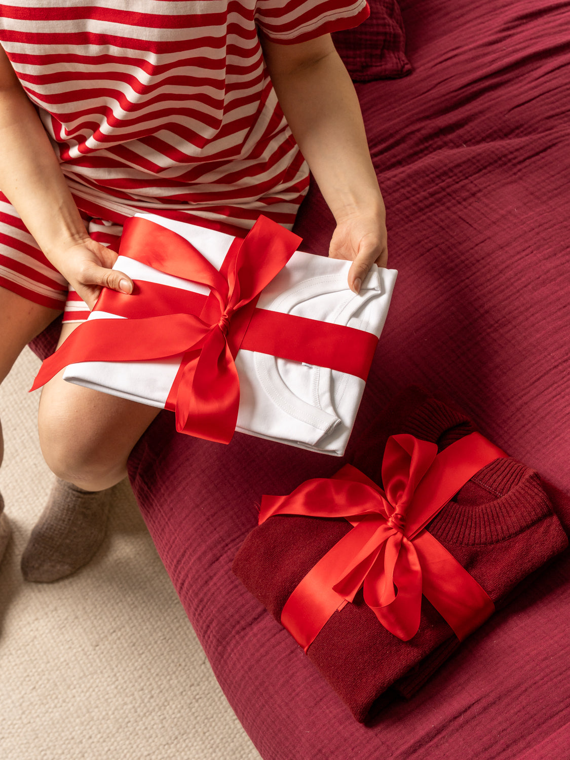 Toiveen joululahjat 2025: kaksi vaatetta paketoituna punaiseen lahjanauhaan.